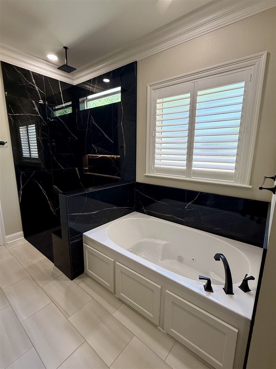Master bathroom with black marble walk-in shower, rain head and jetted tub