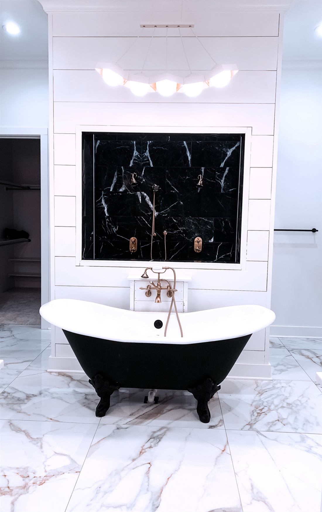 Luxury master bathroom remodel with black clawfoot tub, marble shower and brass fixtures